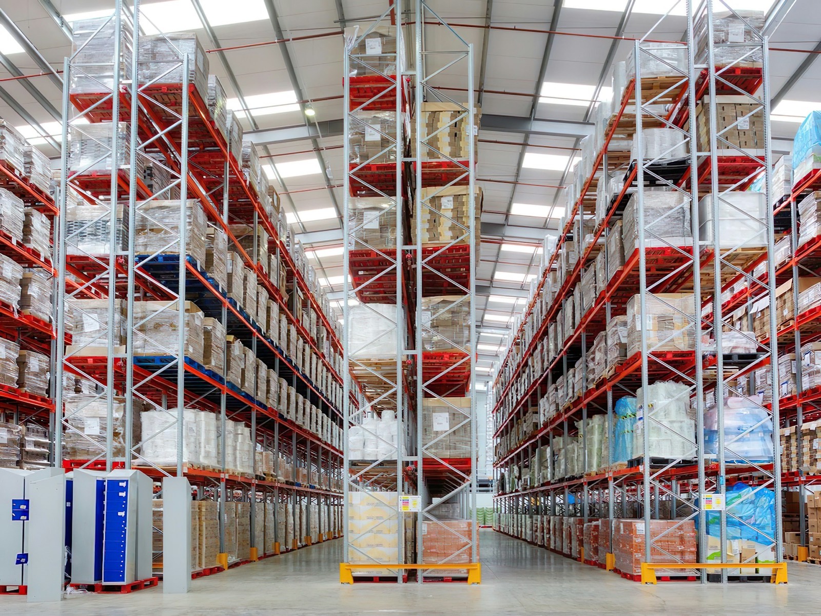 Tall pallet racks stocked with boxed goods along a warehouse aisle